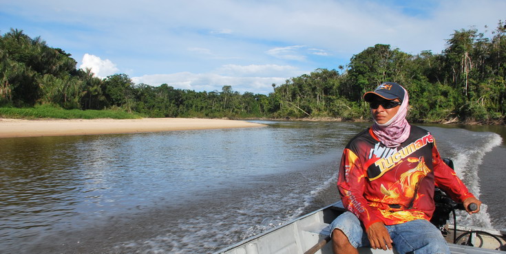 rybarska motorova lod na rece obklopene pralesem